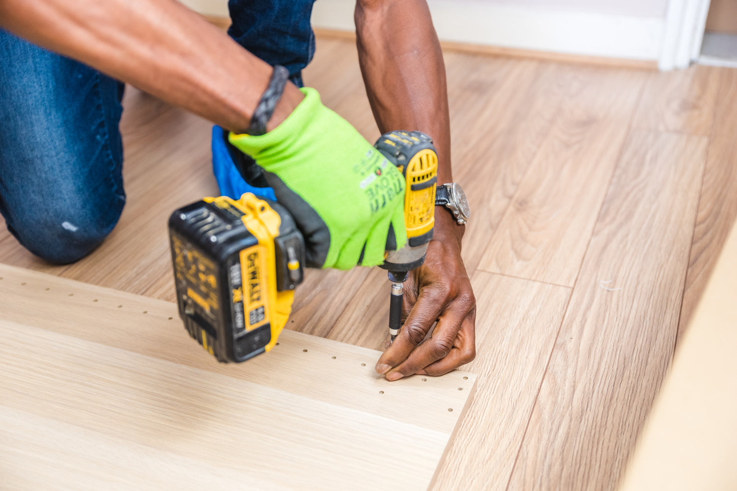 Hands using drills on the wood floor